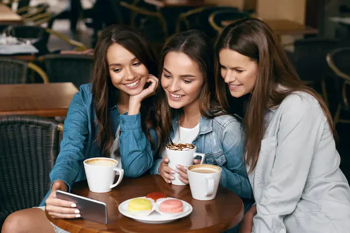 un grupo de amigas creando contenido en una cafeteria aesthetic