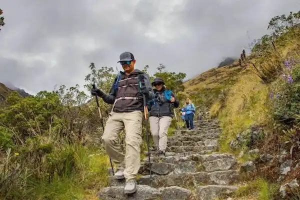 Personas bajando una escalera hecha de piedras ubicada en una montaña.