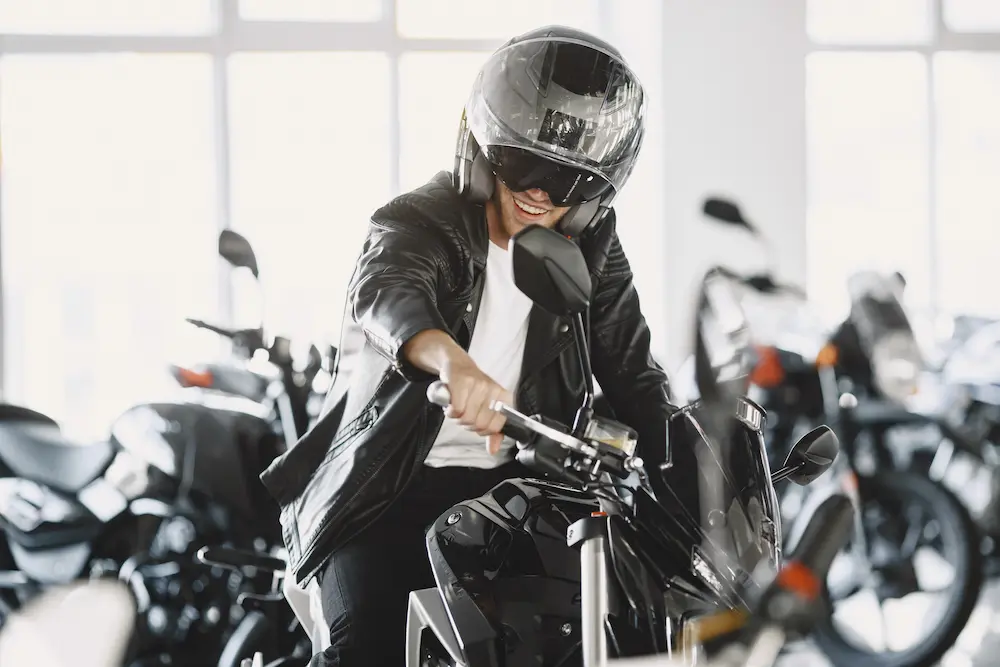 hombre eligiendo motocicletas en la tienda de motos