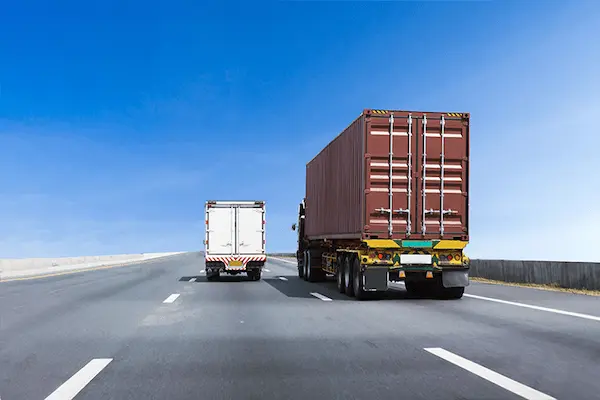 camiones de carga circulando en carretera durante un viaje de transporte