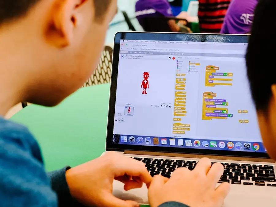Niño usando Scratch en una laptop para crear un proyecto de programación visual.