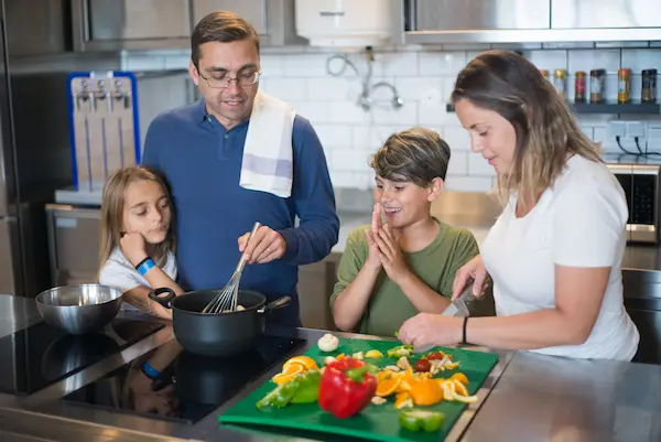 Padres e hijos compartiendo tiempo juntos, cocinando